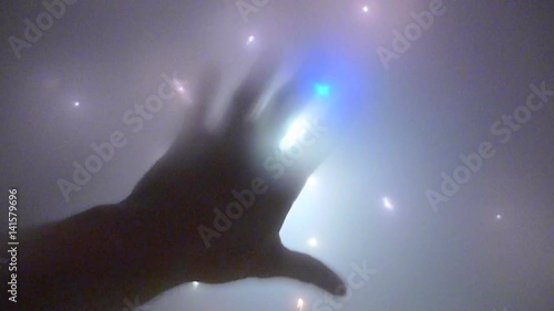 Abstract visual hand and overhead lights appearing to be an alien space craft.