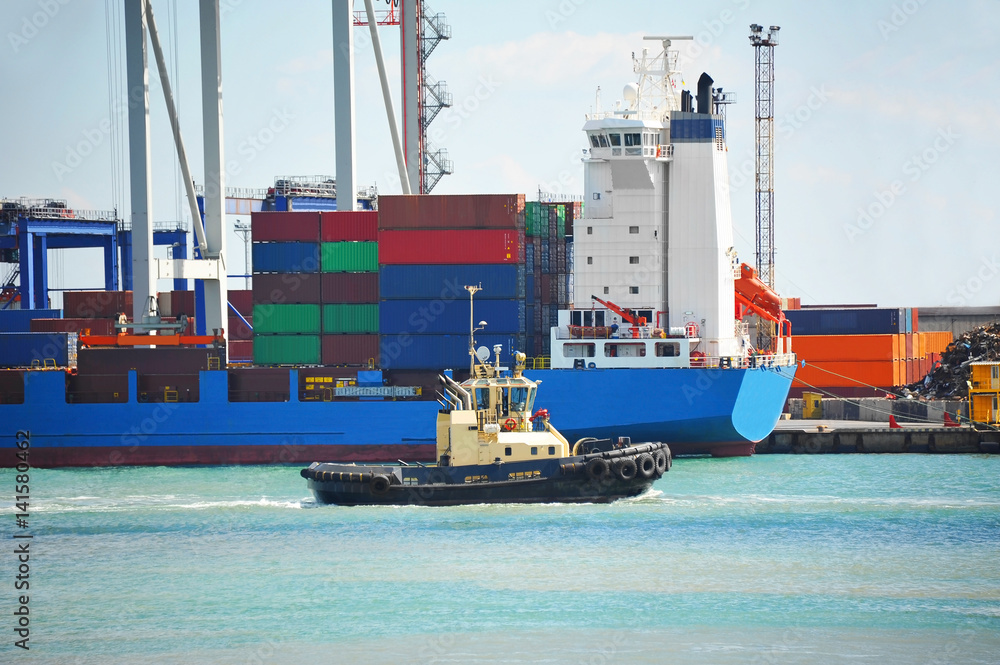 Fototapeta premium Tugboat assisting cargo ship