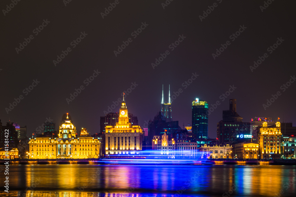 Fototapeta premium Night view of River Boats on the Huangpu River and as Background the Skyline of the Northern Part of Puxi 