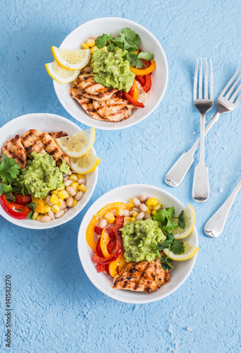 Grilled chicken fajitas bowls on a blue background, top view. Flat lay