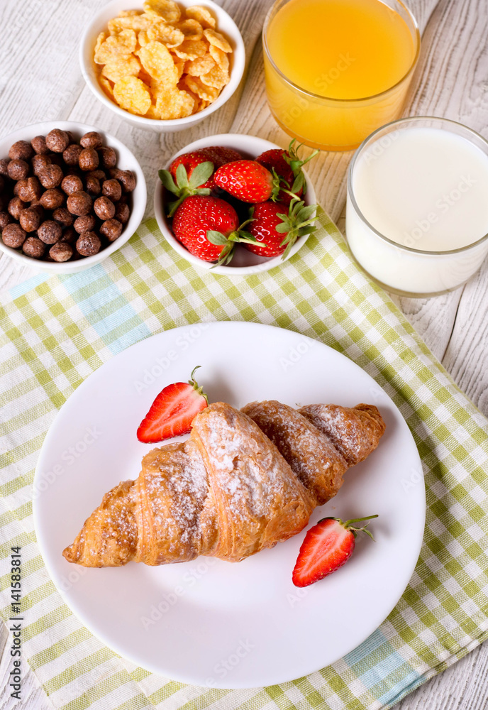 Breakfast with croissants, milk, orange juice and cornflakes Breakfast with croissants, milk, orange juice and cornflakes