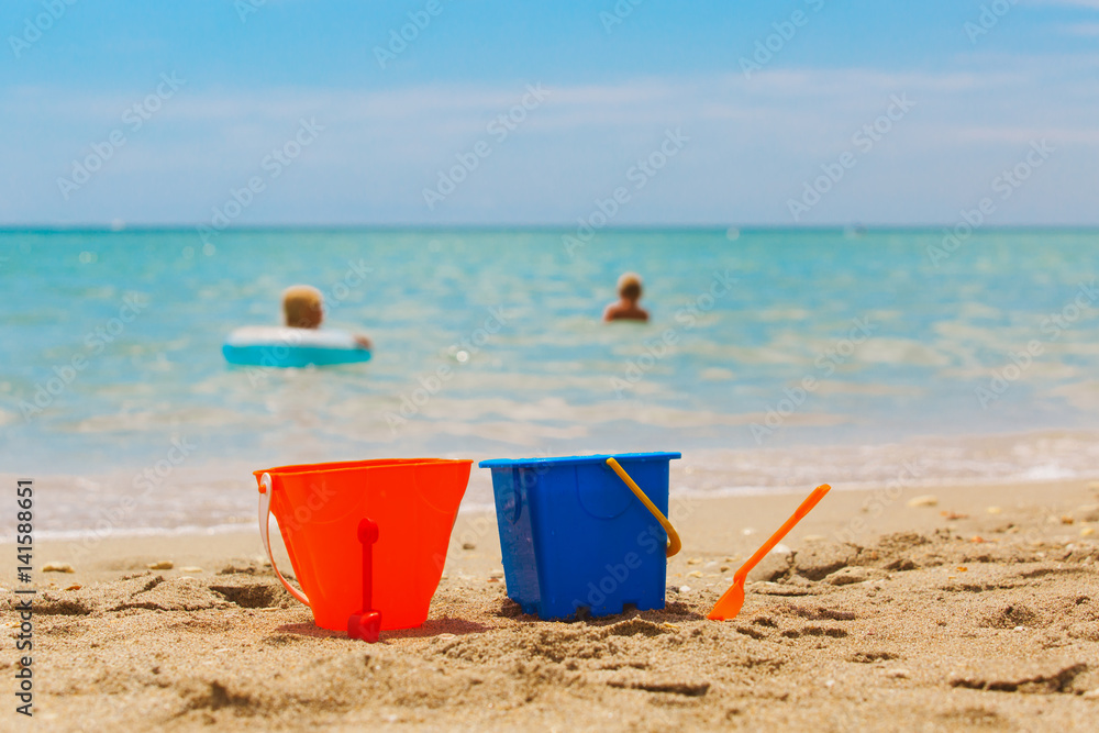 toys and kids swim at beach - family vacation concept toys and kids swim at beach - family vacation concept