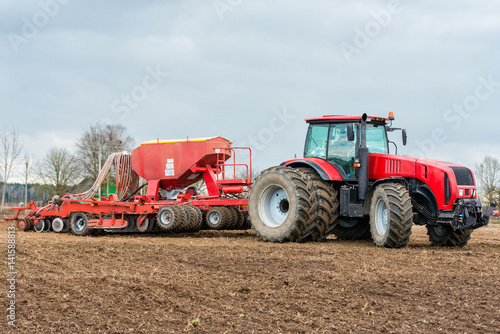 Farmer tractor working in the field. Spring time for sowing. Planting crops.