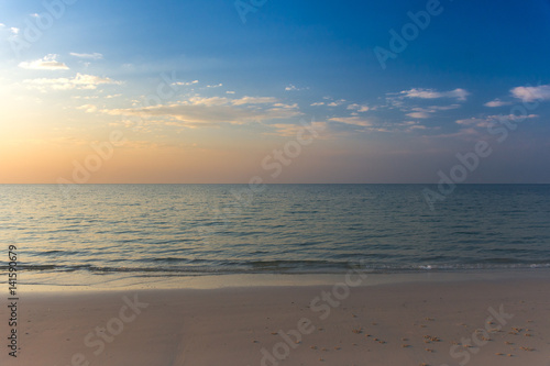 Empty white sandy beach and clear sea at early sunset.