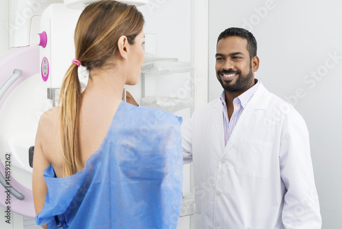 Happy Doctor Preparing Patient For Mammogram Test