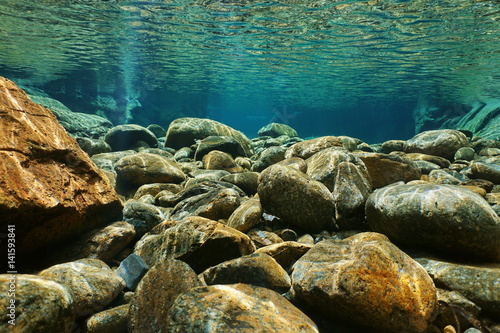 River underwater rocks on a shallow riverbed with clear water, Dumbea, Grande Terre island, New Caledonia
