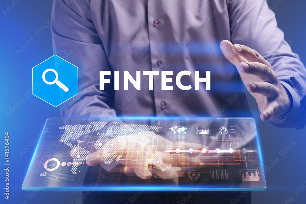 Fototapeta premium Business, Technology, Internet and network concept. Young businessman working on a virtual screen of the future and sees the inscription: Fintech