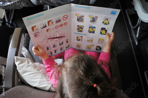 Little girl reads the safety information card photo