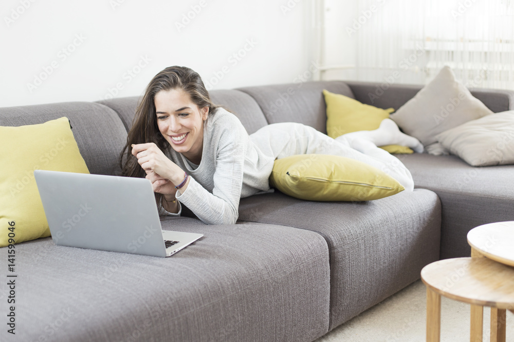 Young woman working on laptop at home. Morning scene