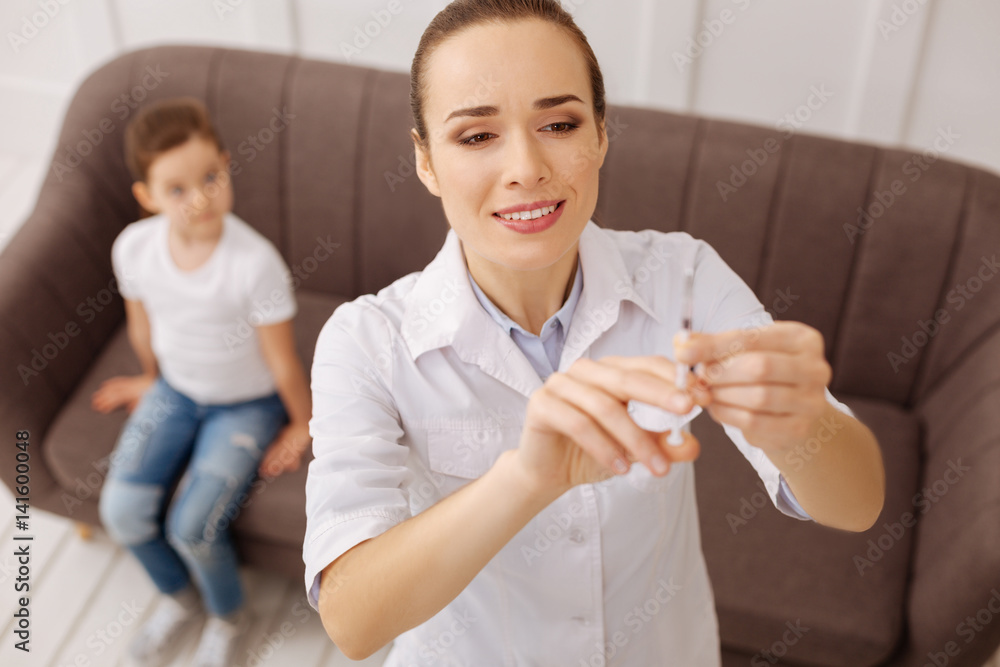 Competent pediatrician being careful with vaccine proportions Competent pediatrician being careful with vaccine proportions