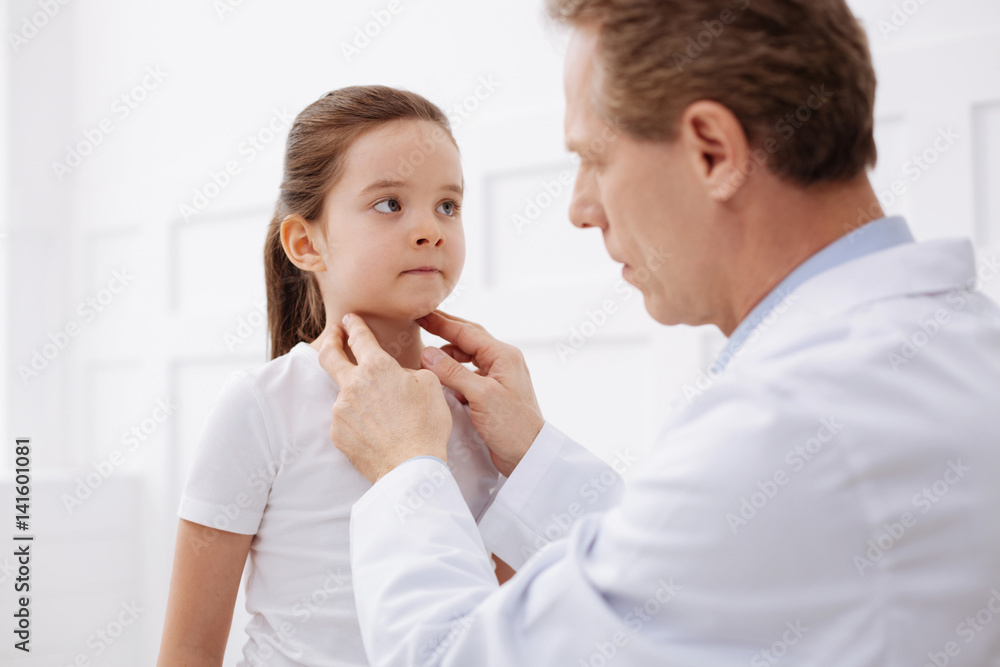 Excellent physician checking his patients neck Excellent physician checking his patients neck