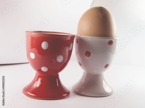 egg in white egg cup with red egg cup