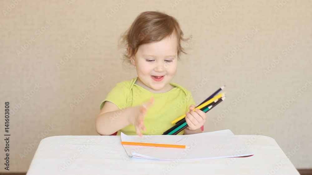 A little girl draws with colored pencils A little girl draws with colored pencils