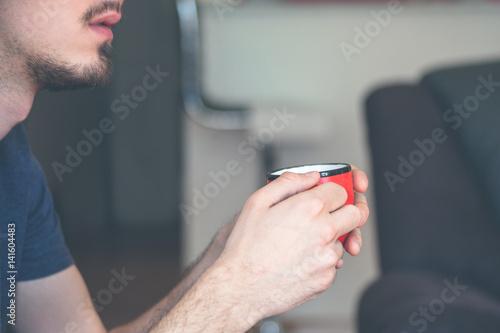 young man hold cup of morning coffee