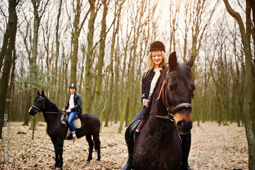 Young stylish couple riding on horses at autumn forest. © AS Photo Family