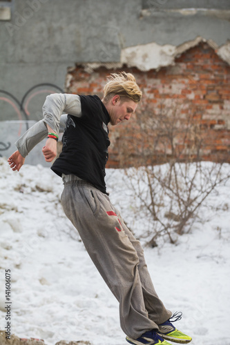 Parkour jumping in winter snow park - free-run training photo