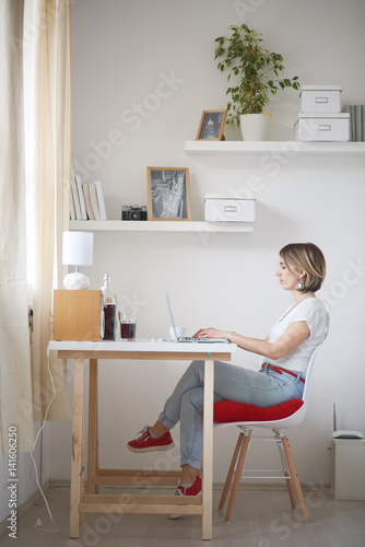 woman reading / listening music using tablet / laptop at home