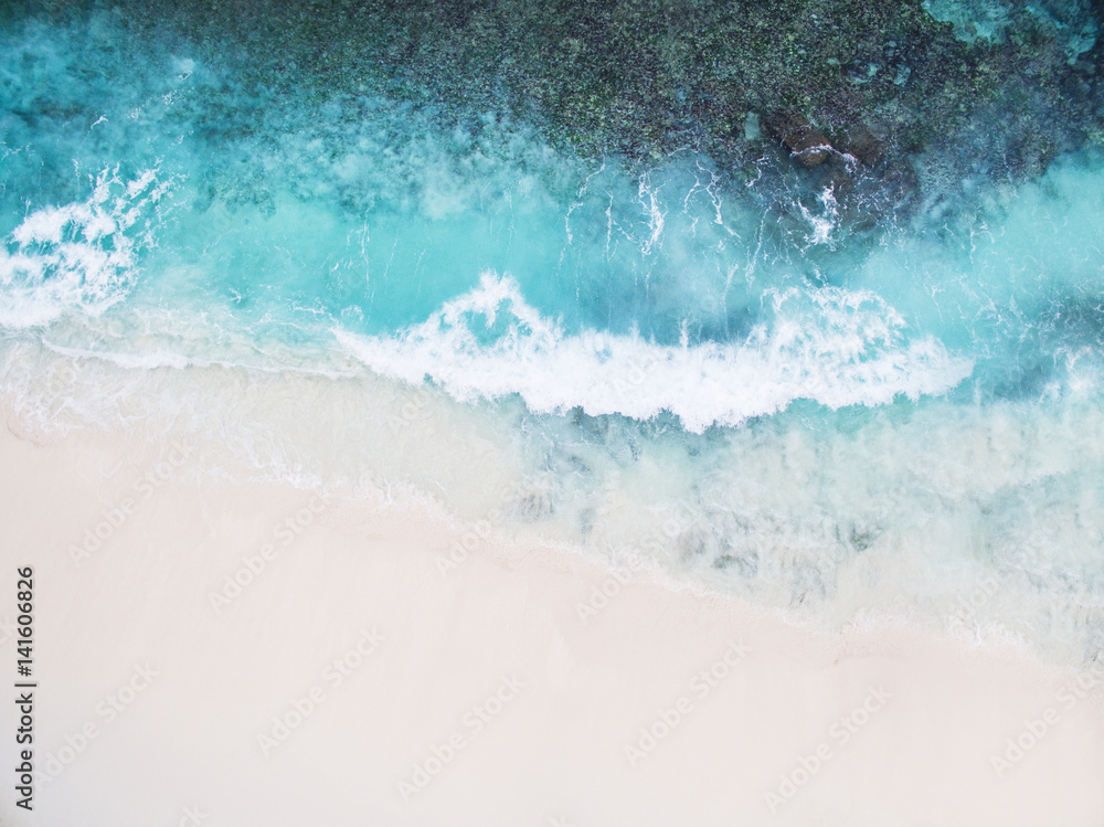 Beautiful tropical white empty beach and sea waves seen from above. Seychelles Grand Anse beach aerial view