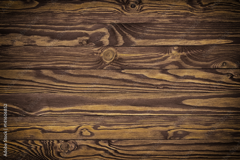 Naklejka premium Dark brown scratched wooden cutting board. Wood texture background