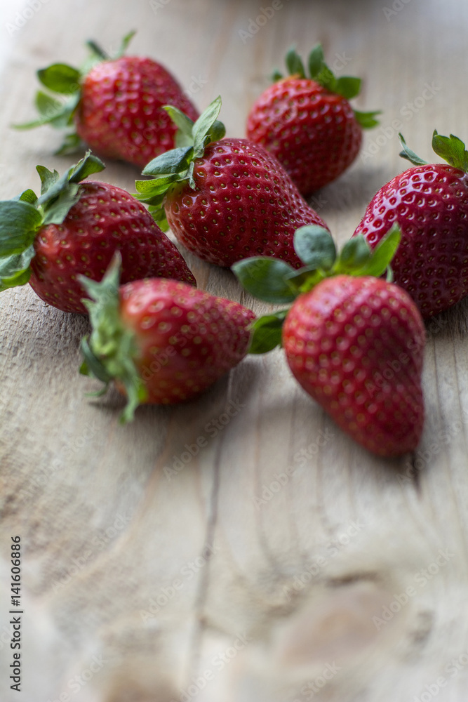 Big fresh strawberries are on the wooden background