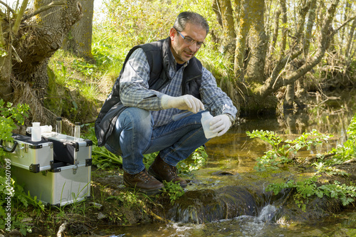 View of a Biologist take a sample in a river. photo