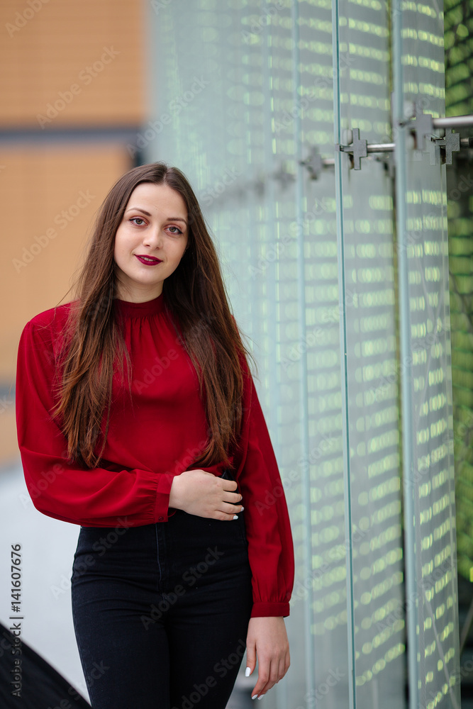 Young business woman standing near wall and smile to camera