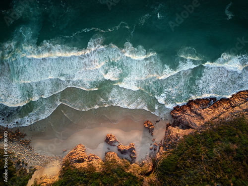 Waves breaking on coastline from overhead photo
