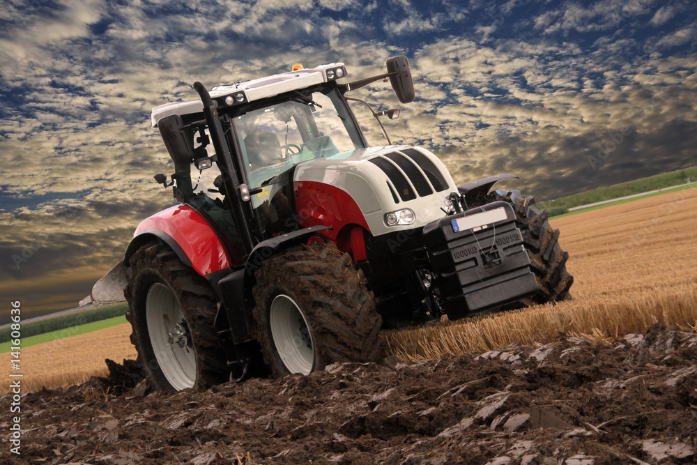 Fototapeta premium Traktor bearbeitet landwirtschaftlichen Boden