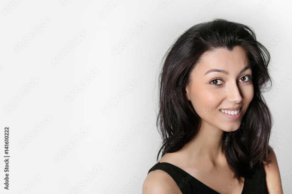 Beautiful smiling girl with clean skin, natural make-up, and white teeth on gray background Beautiful smiling girl with clean skin, natural make-up, and white teeth on gray background