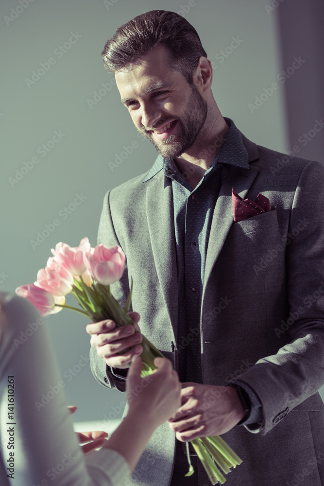 Man presenting flowers to woman Man presenting flowers to woman