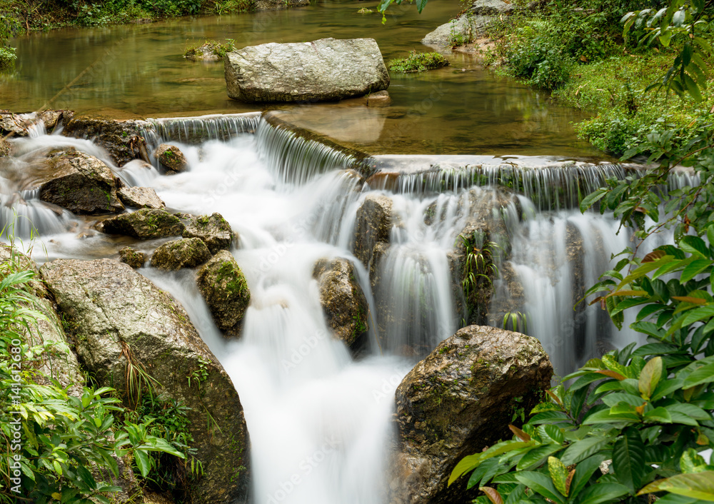 Beautiful view of waterfall landscape. Small waterfall in deep green forest scenery Beautiful view of waterfall landscape. Small waterfall in deep green forest scenery