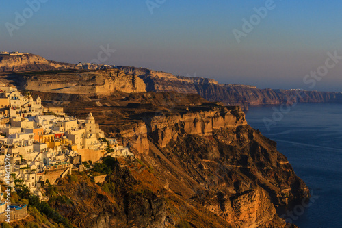 Amazing sunset view with white houses in Oia village on Santorini island in Greece. 