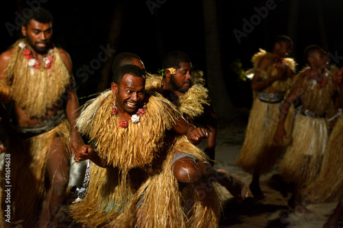 Fijian men dancing a traditional male dance meke wesi in Fiji photo