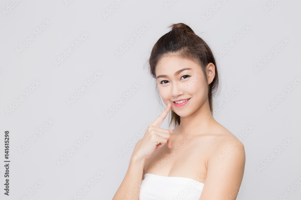 Asian beautiful woman smiling and pointing at her lips Asian beautiful woman smiling and pointing at her lips