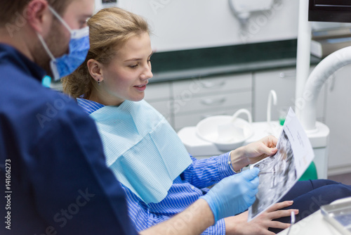Doctor talking with patient and teaching a radiograph. Dentist concept.