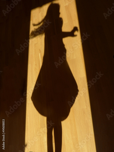 shadow of a girl dancing in the door opening