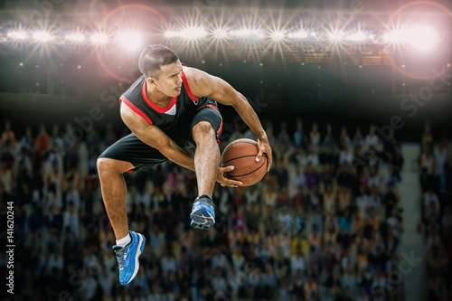 basketball player jumping and dribbling ball in the air,Action in the stadium during match