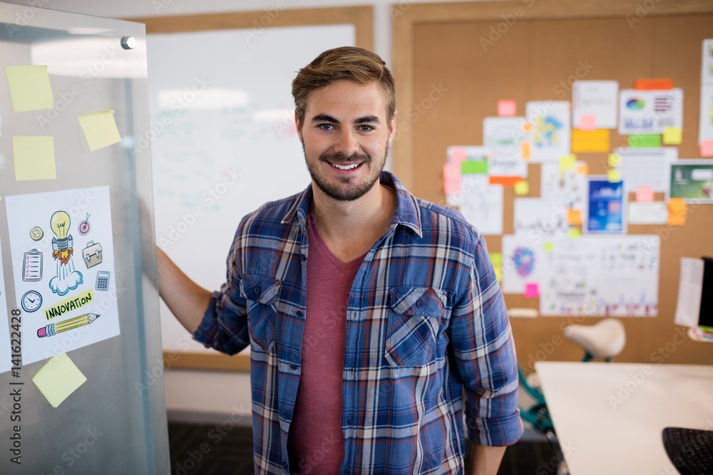 Fototapeta premium Smiling man standing near the wall with sticky notes