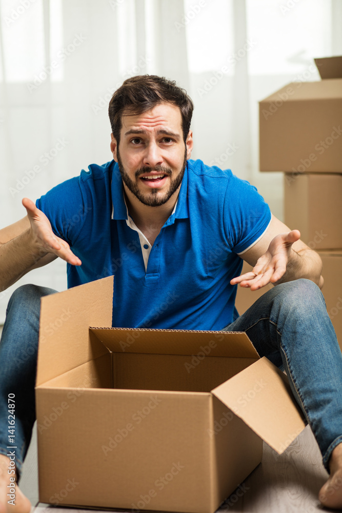 man lying on the floor with packing boxes behind man lying on the floor with packing boxes behind