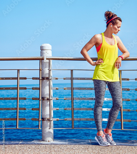 Canvas Print young athlete relaxing after workout at embankment