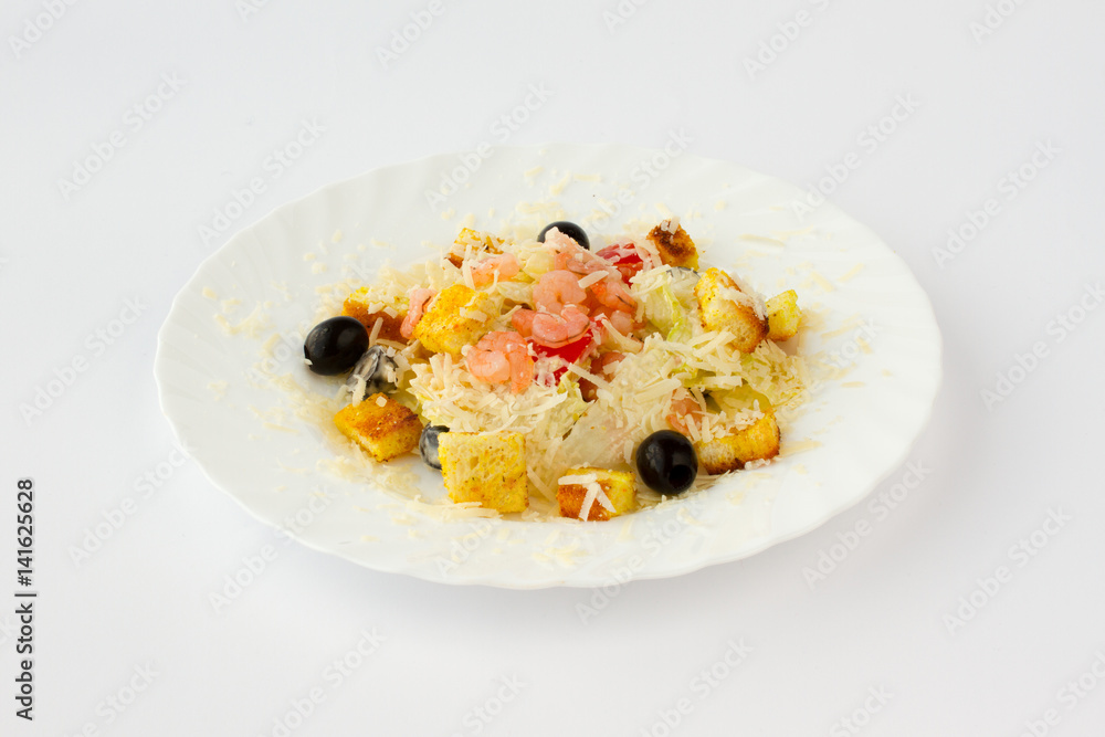 Салат из креветок с гренками и маслинами пересыпан тертым твердым сыром 
