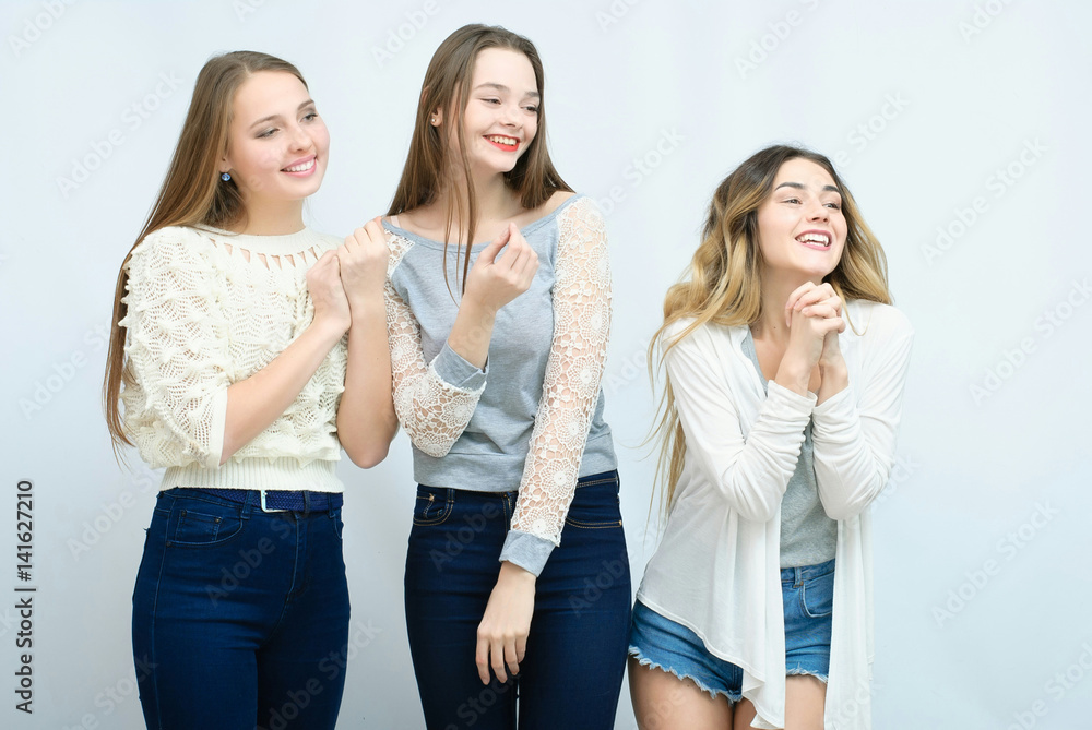 Three stylish sexy hipster girls best friends.Standing together and having fun. Looking at camera. Over gray background. Three stylish sexy hipster girls best friends.Standing together and having fun. Looking at camera. Over gray background.