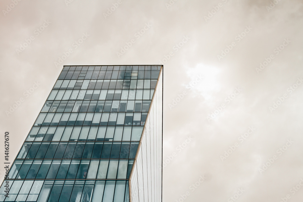 Fototapeta premium Modern office building with stormy cloudy sky