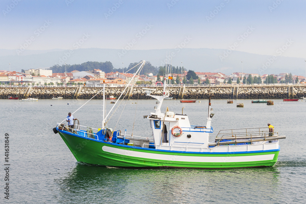 Green fishing boat at harbor