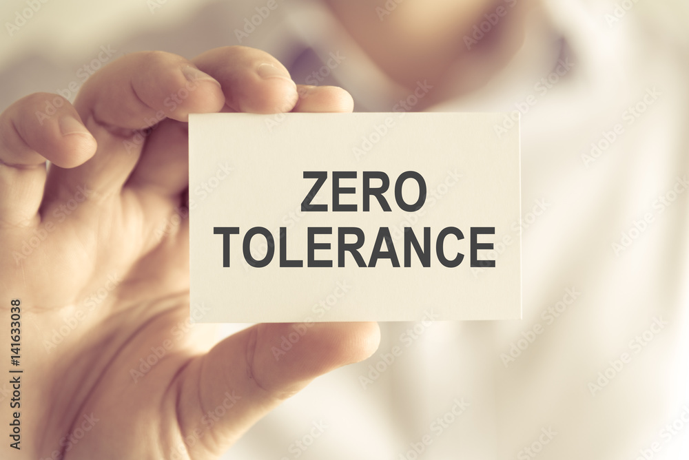 Businessman holding ZERO TOLERANCE message card