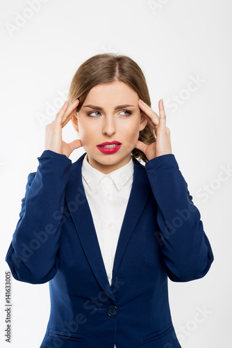 Young business woman working at office in stress suffering intense headache