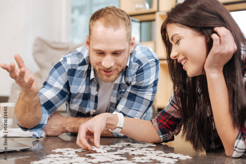 Happy delighted people doing a jigsaw puzzle Happy delighted people doing a jigsaw puzzle