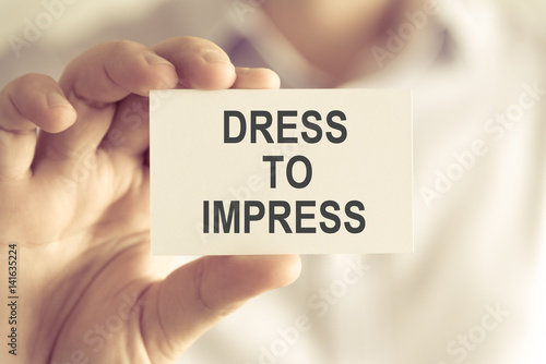 Businessman holding DRESS TO IMPRESS message card