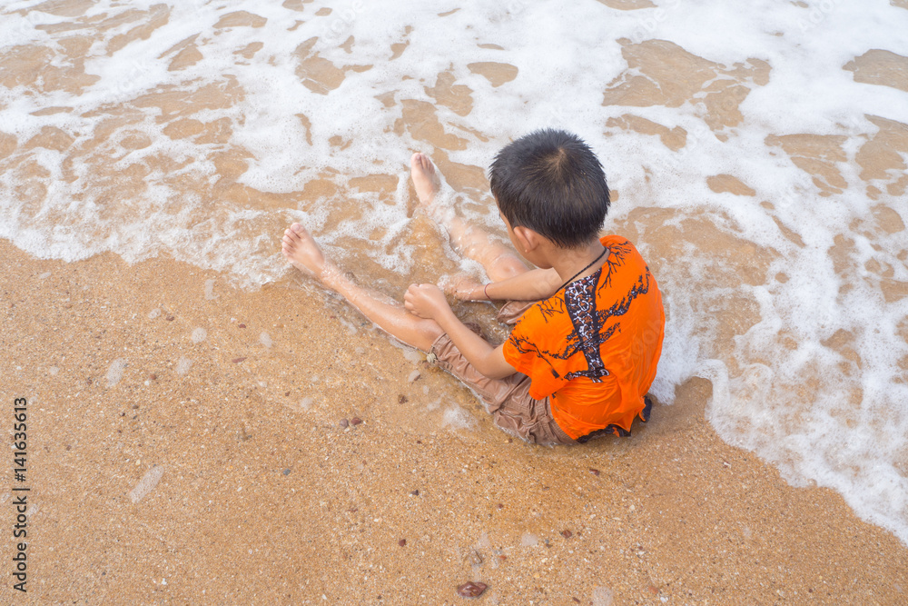 boy playing on the beach in the water