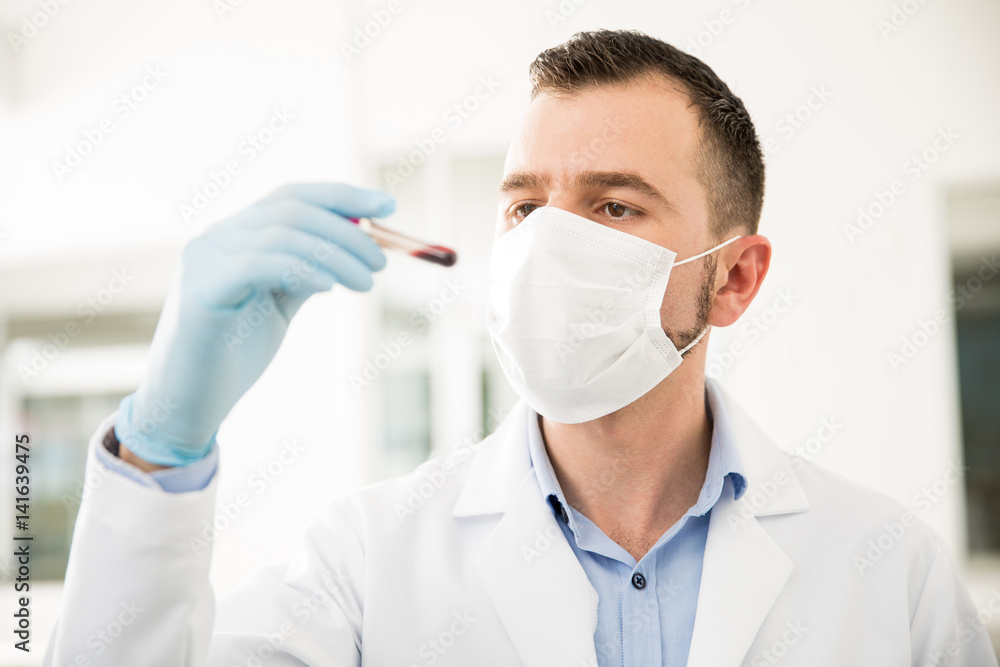 Chemist looking at a blood sample Chemist looking at a blood sample